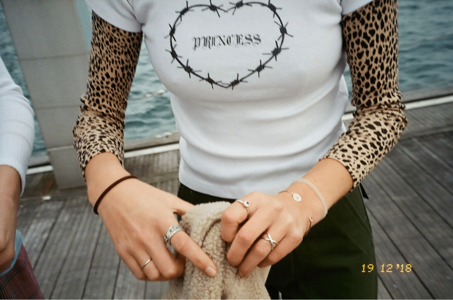 A close-up of Aubrey's outfit, a baby tee that says Princess with a leopard print turtleneck underneath. Shot on 35mm film.