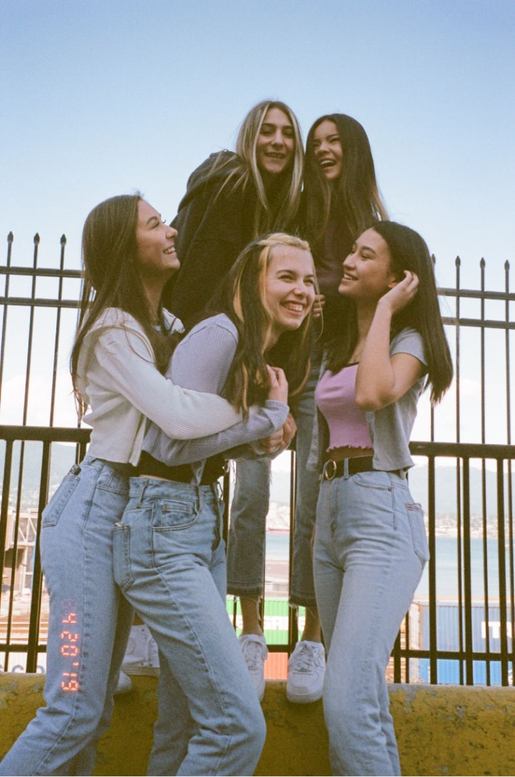A group of girls hugging and laughing together. Shot on 35mm film.