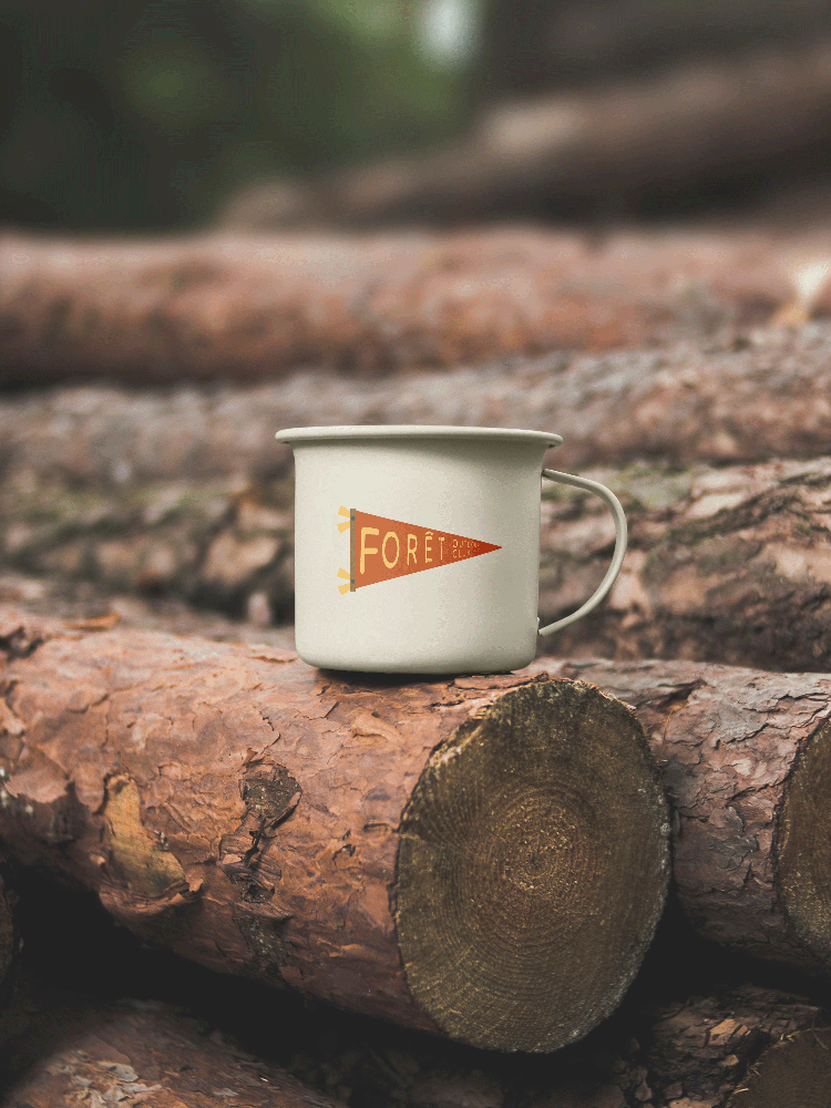 A mockup of an enamel camping mug with a forêt flag illustration on it.